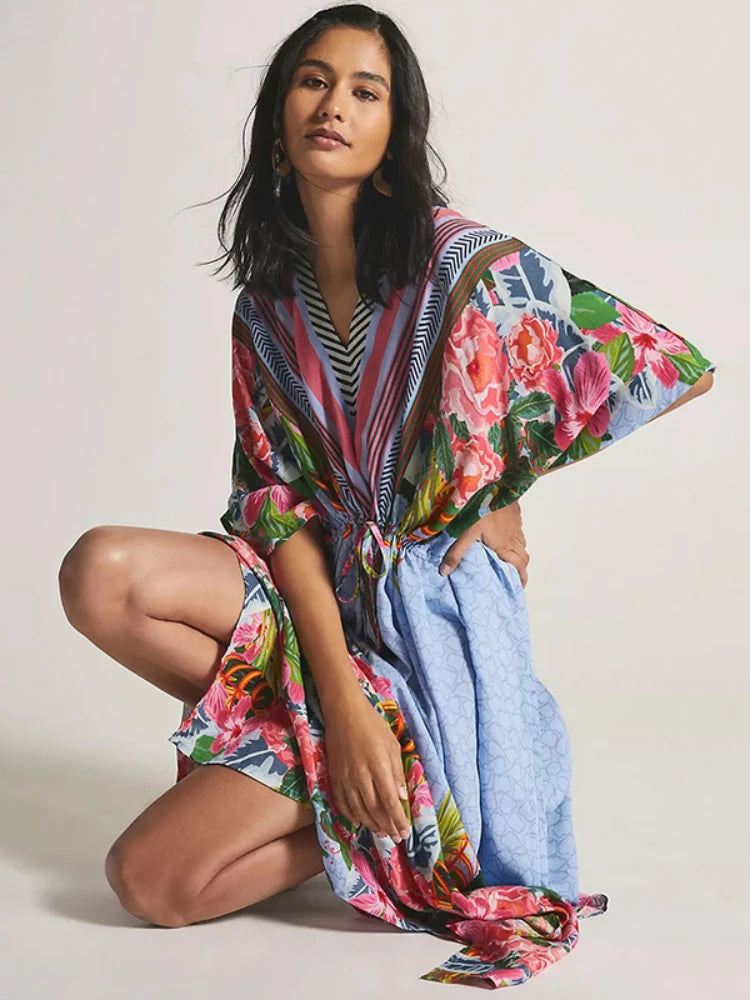 Woman wearing a colorful floral kimono-style garment on a plain background