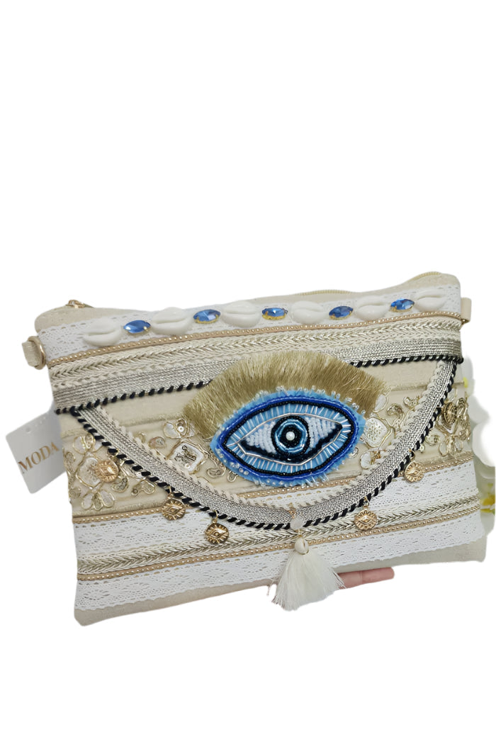Handheld clutch with eye design and decorative elements on a light gray background