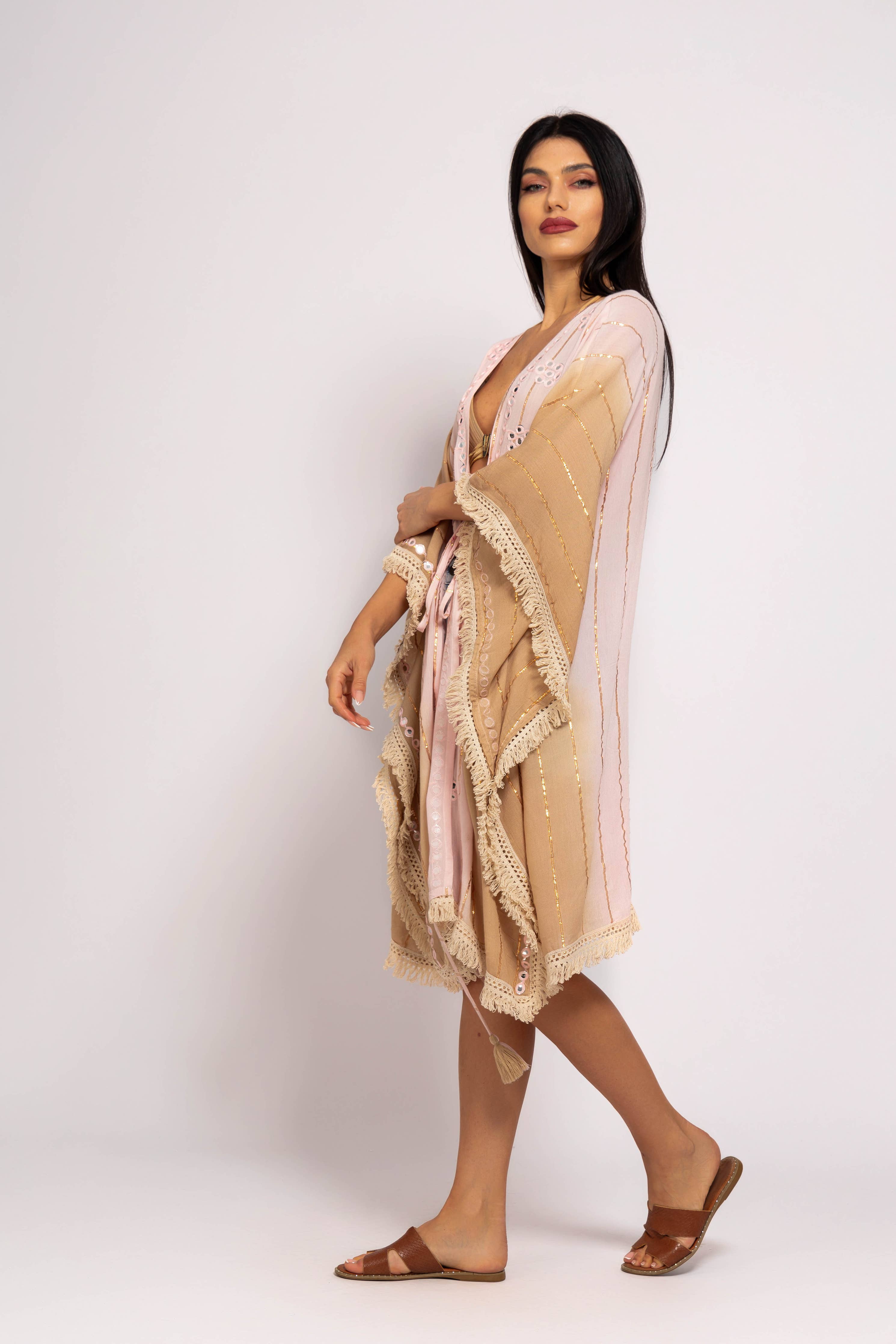 Woman wearing a beige and pink dress with a white background