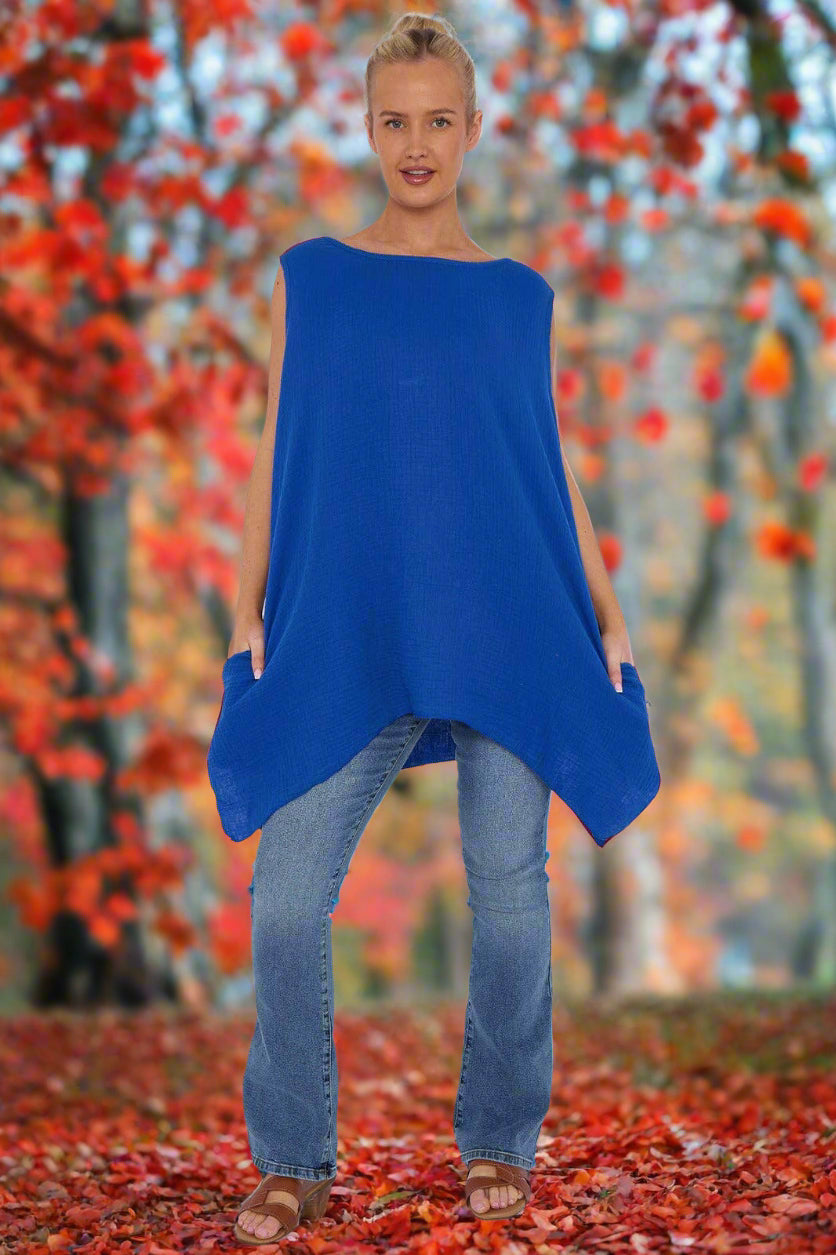 Woman wearing a blue sleeveless top and jeans on a white background