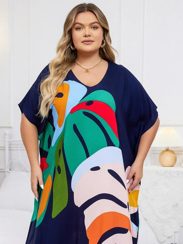 Woman wearing a navy blue dress with colorful abstract patterns in a bedroom setting.